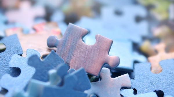 Pension consolidation: image depicts a variety of blue jigsaw puzzle pieces.