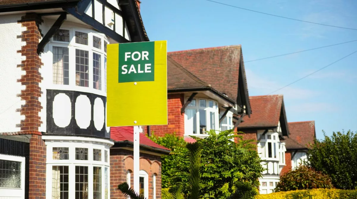 £5k mortgage: image depicts a line of houses in the UK, one with a for sale sign in front of it.