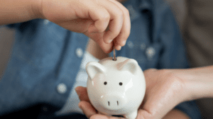 Child putting money in a piggybank